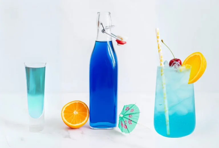 Homemade Blue Curaçao Syrup Recipe: Vibrant, Easy & Flavorful 5 Glass bottle of Blue Curaçao syrup with orange and umbrella