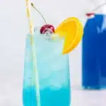 Homemade syrup in glass container next to orange slice