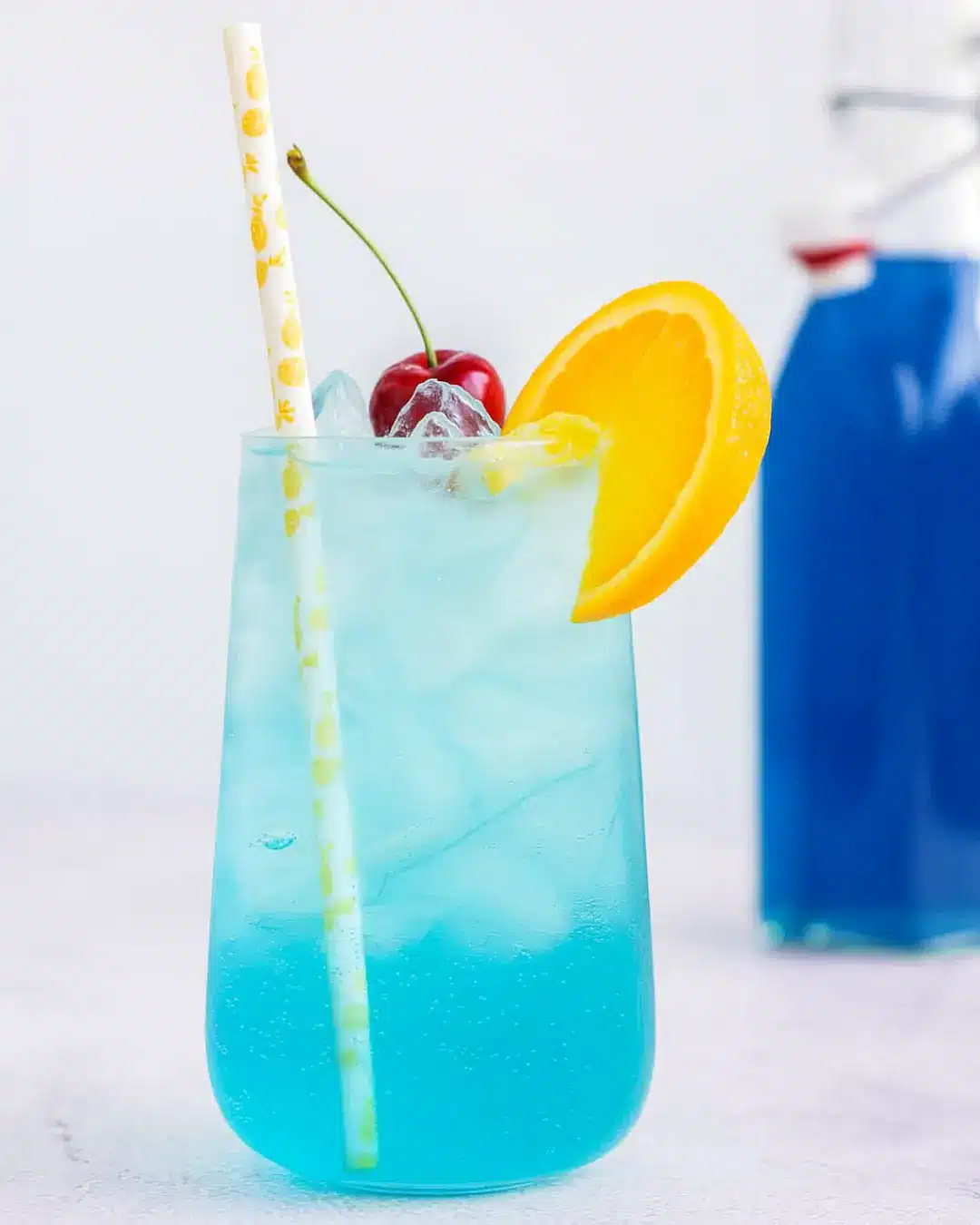 Homemade Blue Curaçao Syrup Recipe: Vibrant, Easy & Flavorful Homemade Blue Curacao Syrup Recipe Homemade syrup in glass container next to orange slice