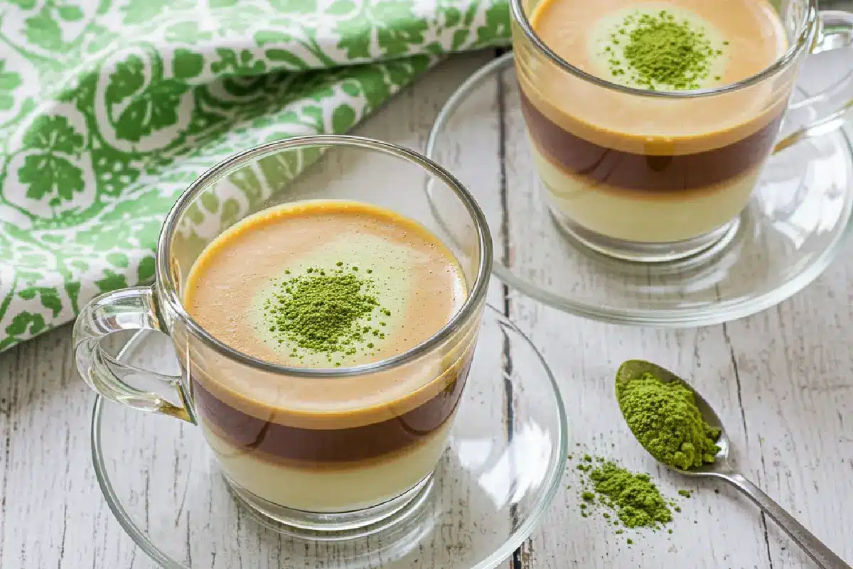 Chocolate protein matcha latte in a clear glass mug