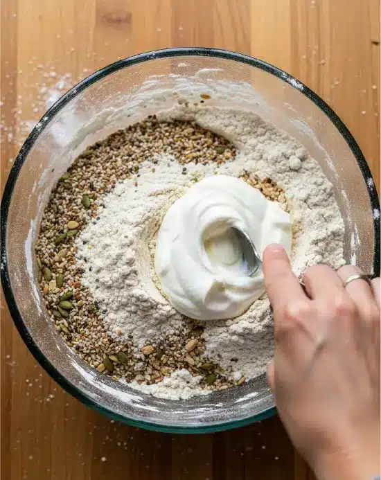 Mixing yogurt into flour for bagel dough