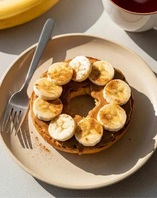 Sweet protein bagel topped with almond butter, cinnamon, and banana - macro tracking protein bagels