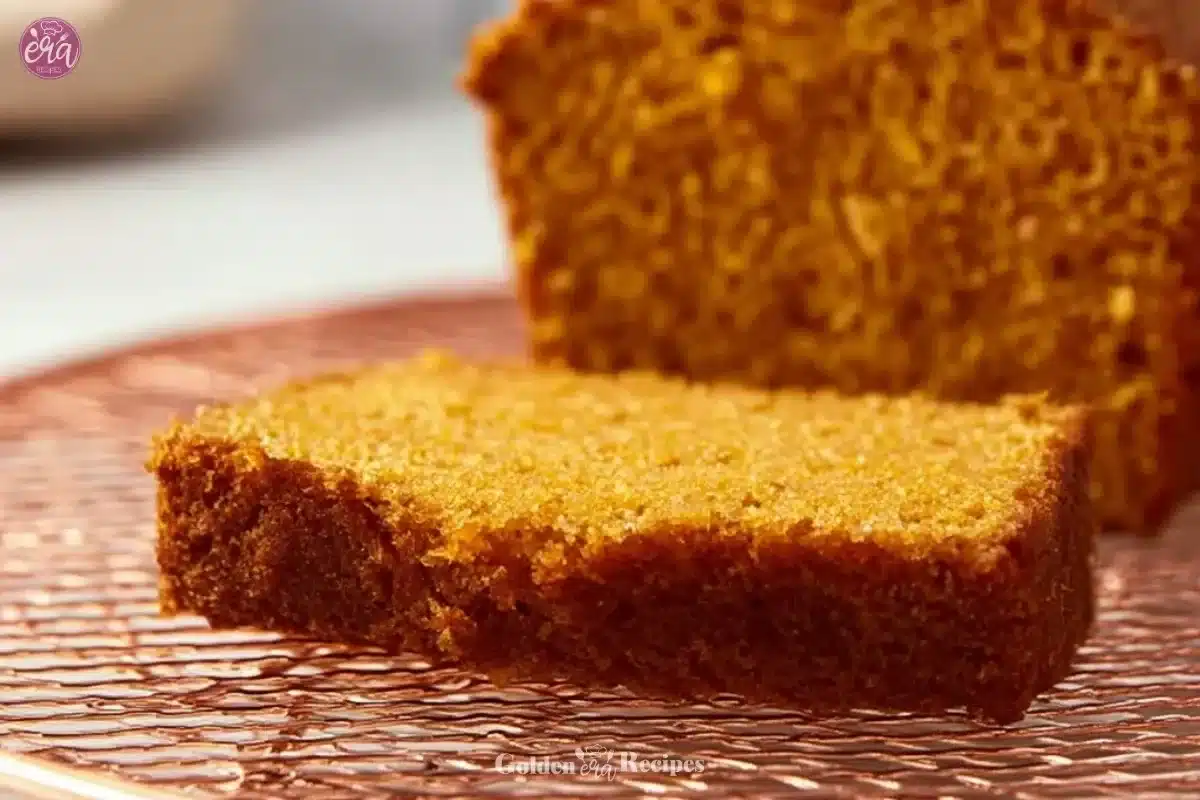 Freshly baked rich and buttery pumpkin bread on a wooden table