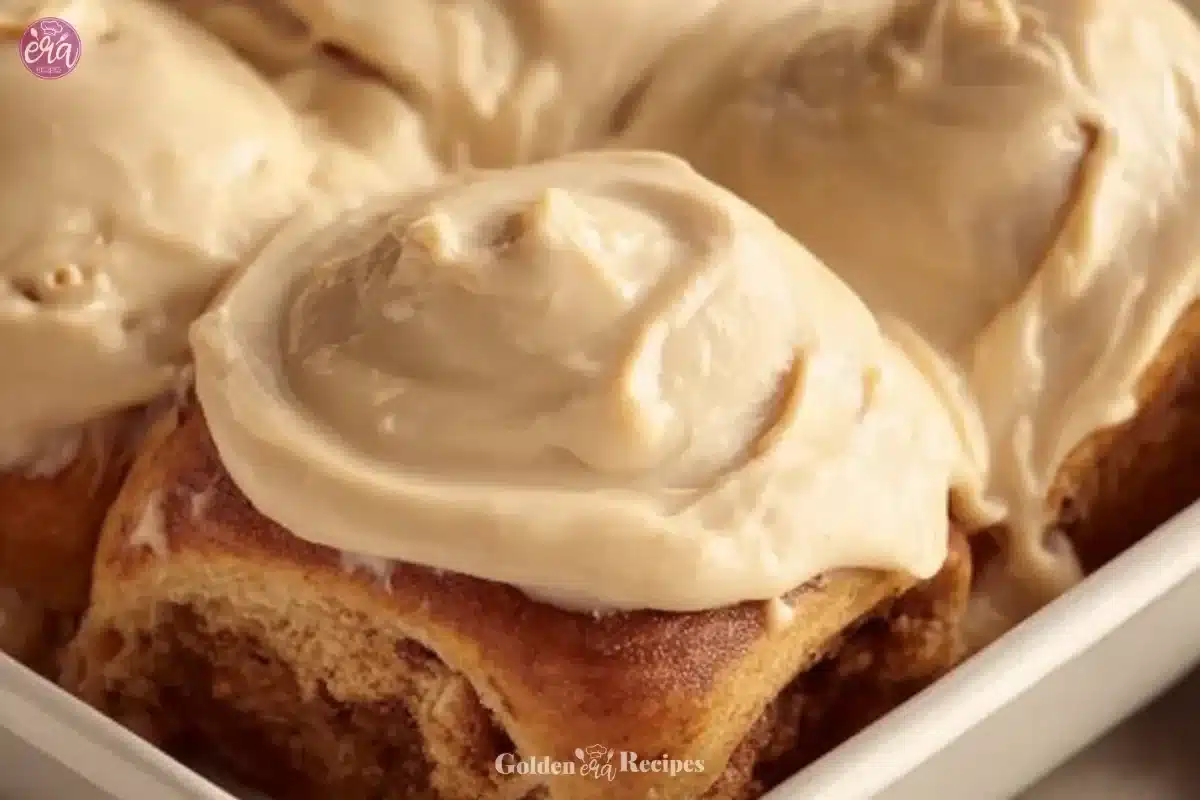 Gingerbread cinnamon rolls topped with creamy glaze for a festive dessert.