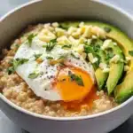 Bowl of savory avocado oatmeal topped with spices and herbs