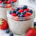 A bowl of creamy chia seed pudding garnished with fresh fruits and nuts.