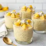 Creamy mango coconut chia pudding in a bowl, topped with fresh mango slices.