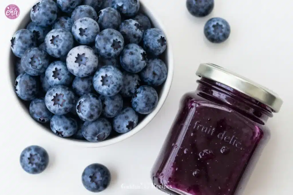Easy Blueberry Simple Syrup 1 Homemade blueberry simple syrup in a glass jar with fresh blueberries.