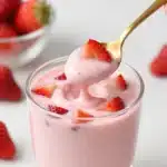 High-protein strawberry cheesecake pudding in a glass with a strawberry topping