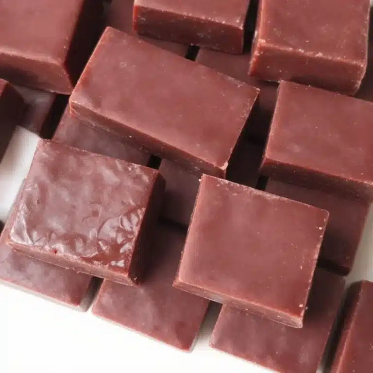 Homemade berry gelatin squares served on a plate with fresh berries