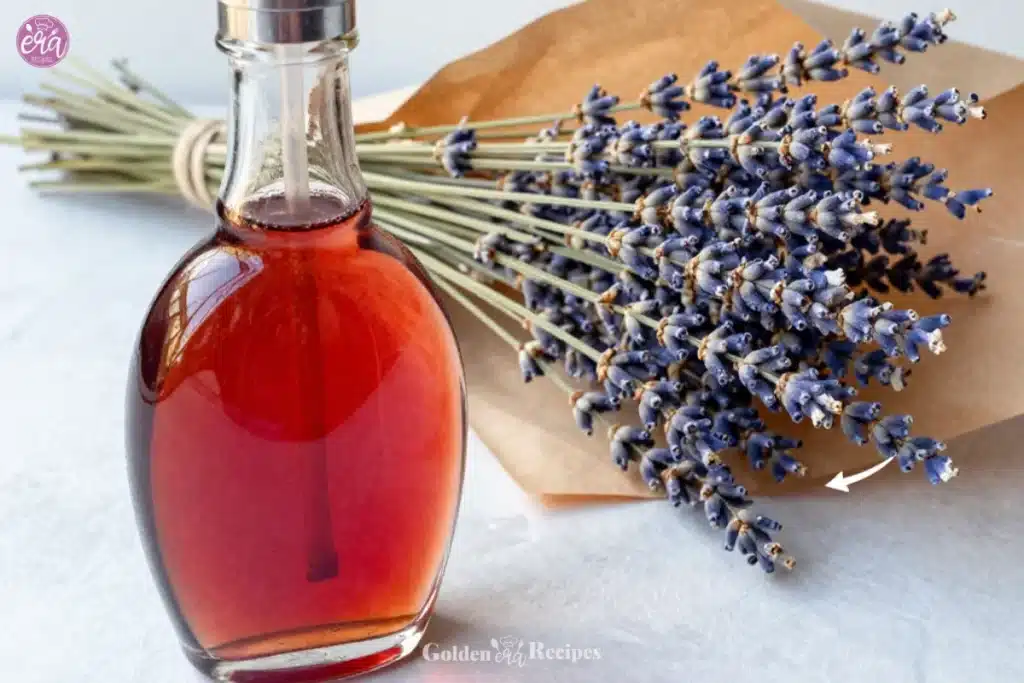 Homemade Lavender Simple Syrup Recipe 1 Homemade lavender simple syrup in a glass bottle with fresh lavender flowers.