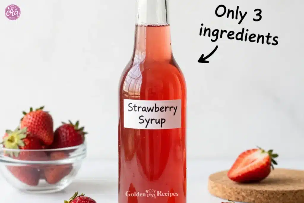 Delicious homemade strawberry syrup in a glass jar with fresh strawberries.