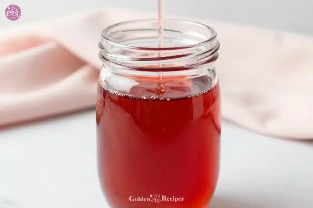 Homemade Strawberry Syrup 1 A jar of homemade strawberry syrup topped with fresh strawberries
