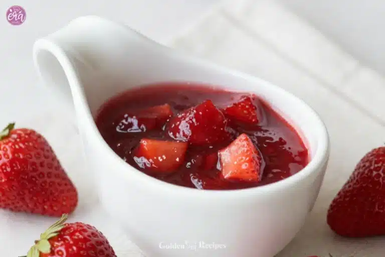 Homemade strawberry syrup drizzled over pancakes on a plate.