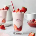 Delicious Korean strawberry milk served in a glass with fresh strawberries.