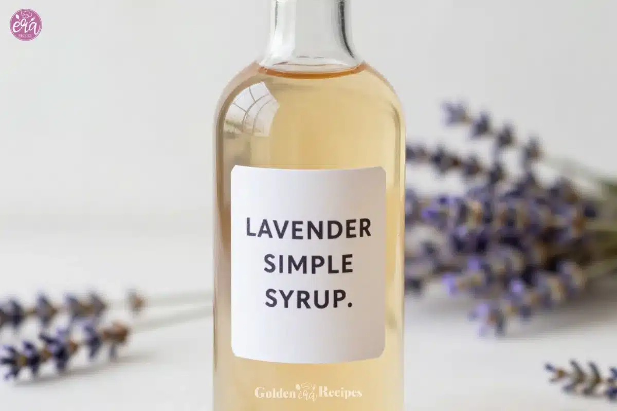 Homemade lavender simple syrup in a glass bottle with lavender flowers
