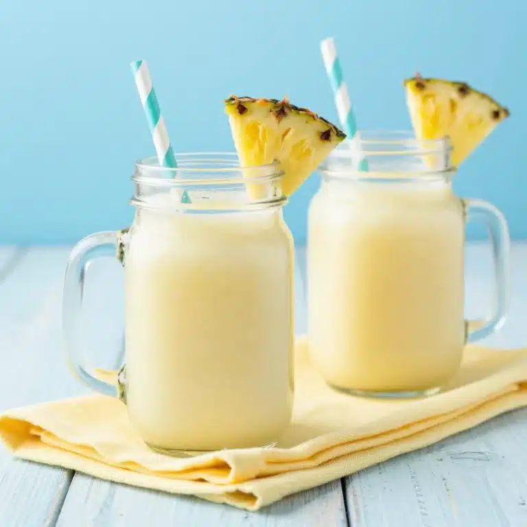 Orange, Pineapple & Coconut Mocktail 7 Refreshing Orange, Pineapple & Coconut Mocktail in a glass with tropical garnishes.
