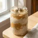 A bowl of peanut butter overnight oats topped with fresh fruit and nuts