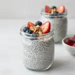 Bowl of vanilla chia pudding topped with fresh berries and nuts