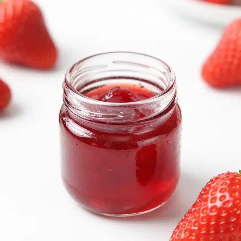 Bottle of berry simple syrup with fresh berries and flowers