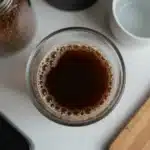 Cinnamon Brown Sugar Coffee Syrup bottle on a wooden table with coffee cup