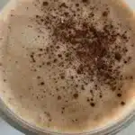 Coffee Protein Smoothie Gentle Embrace in a glass with coffee beans and protein powder.