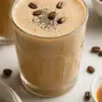 Creamy coffee smoothie garnished with coffee beans and whipped cream