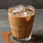 Cup of protein coffee topped with creamy foam and cocoa powder