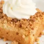 Delicious pumpkin dump cake topped with whipped cream and fall spices